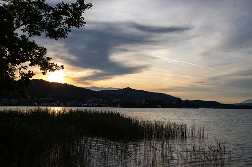 A beautiful landscape view of a lake at sunset on mountains background
