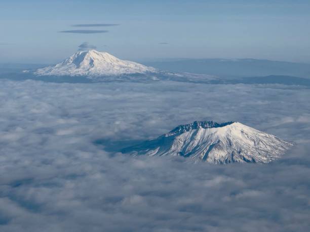 istock Aerial view of snow covered mountain surrounded by clouds 1465812020