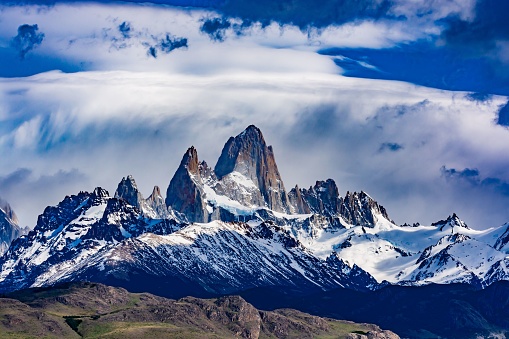 A beautiful view of Mount Fitz Roy covered in snow with dense clouds above in Patagonia