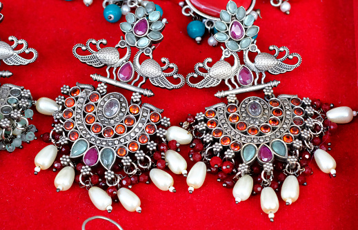 Vitage ethnic metallic earrings with white enamel isolated over white