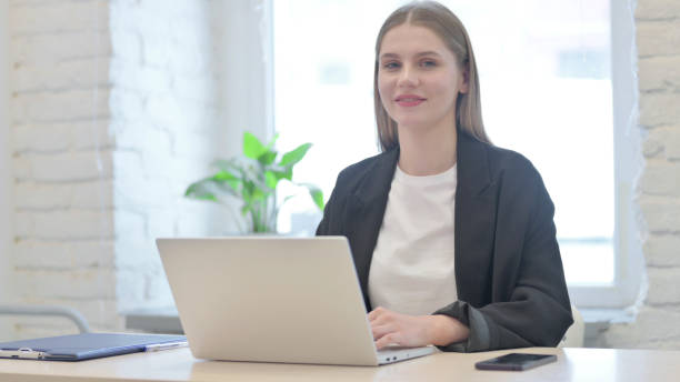 istock Young Businesswoman Shaking Head in Acceptance While Working on Laptop 1465816344