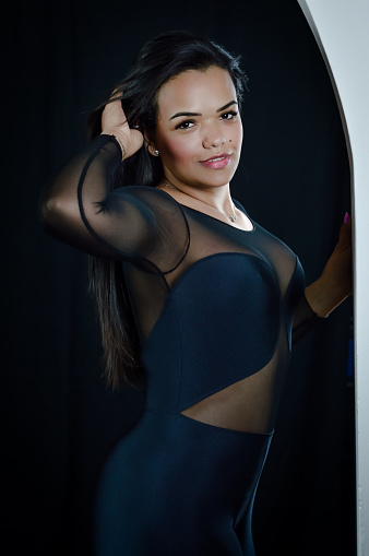 Portrait Of A Beautiful Young Brazilian Woman Dressed In A Skintight  Bodysuit Fixing Her Hair Seductively Stock Photo - Download Image Now -  iStock