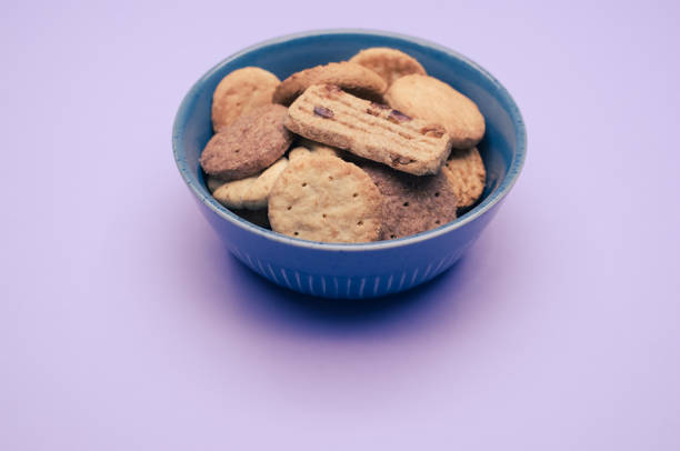 istock Vertical shot of biscuits in a bowl on a mauve background 1465819666