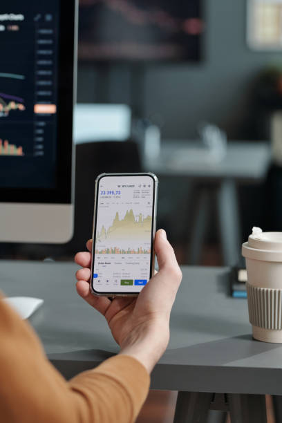 istock Hand of analyst holding smartphone with financial statistics on screen 1465820085