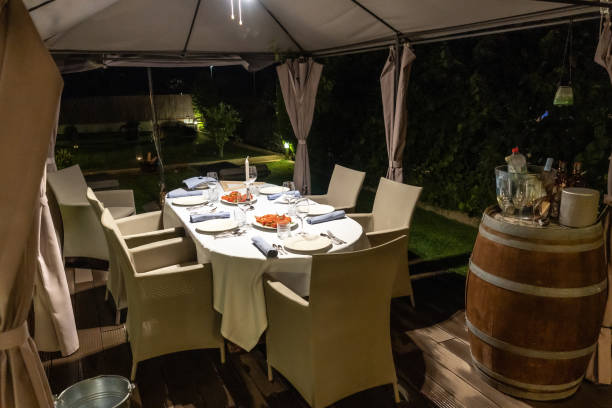 istock Dinner table with beautiful decorations, dishes and a tomato salad in the middle in the evening 1465820401