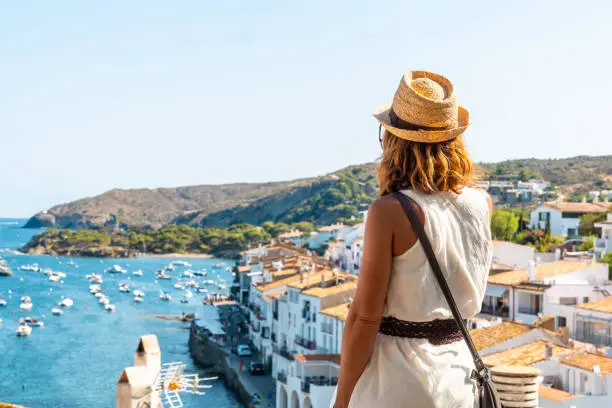 A young woman on vacation on the viewpoint facing the city of Cadaques