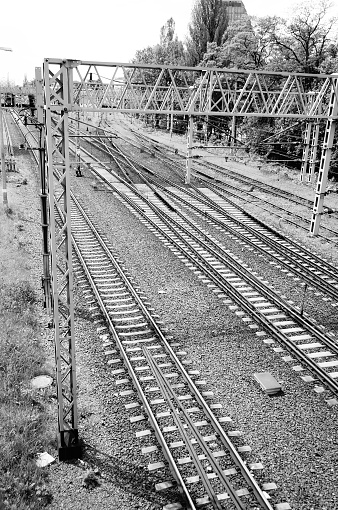 A grayscale shot of a railway during the daytime