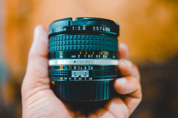 A selective closeup of a camera lens in a hand