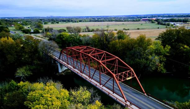 istock Drone shot of a red metallic structure on a bridge surrounded by lush trees 1465826945