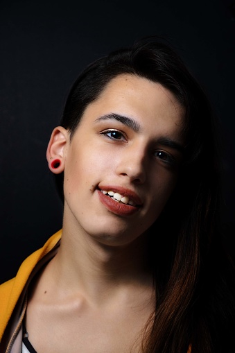 A vertical shot of a young caucasian female against a black background