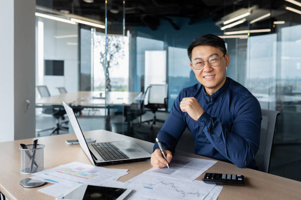 istock A successful young man businessman Asian works in the office, works with documents, graph, accounts 1465830962