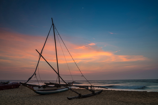 Sunset with traditional fishing sailboat at Negombo Beach, Negombo, Gampaha District, Occidental province, Sri Lanka