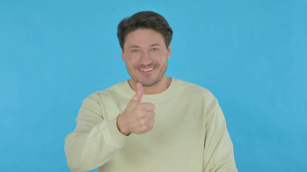 istock Thumbs Up by Young Man on Blue Background 1465840501