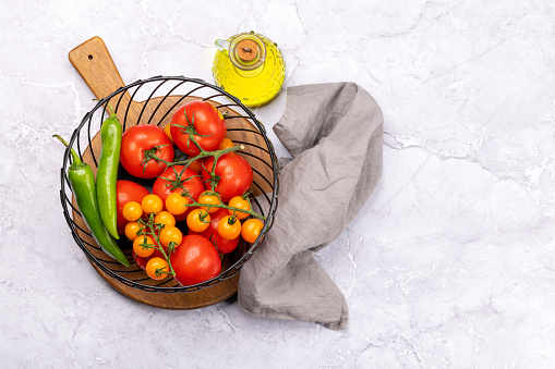 Fresh garden vegetables in basket. Tomatoes and pepper. Italian cuisine. Flat lay with copy space