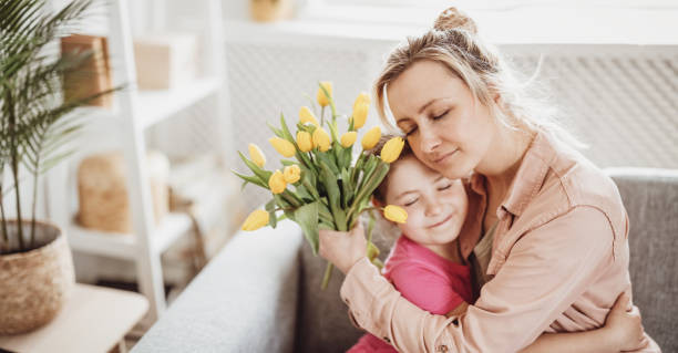 istock Mother and daughter sitting on the sofa and hugging. 1465848660