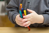 Baby child holds multi-colored crayons in his hands