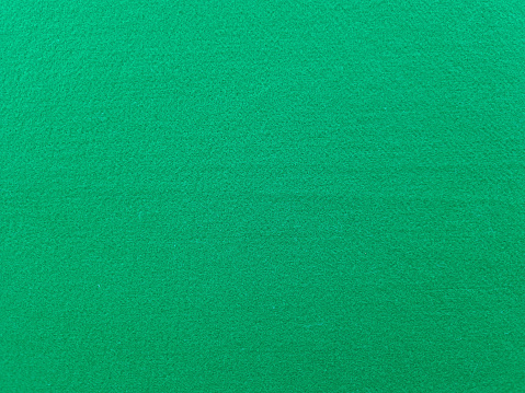 Texture of felt fabric in dark green color for background. Casino golf course
