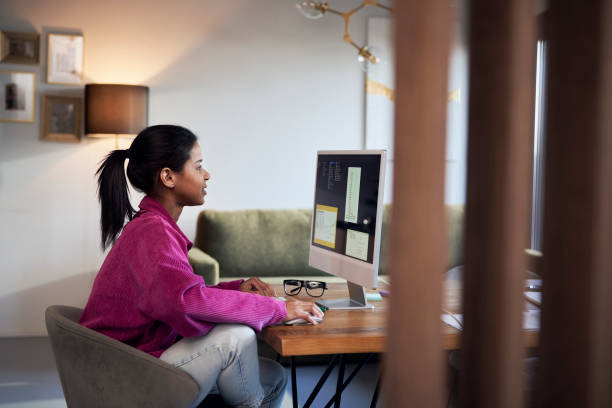 istock Woman in purple jacket working on computer at home and analyzing diagrams 1465860503