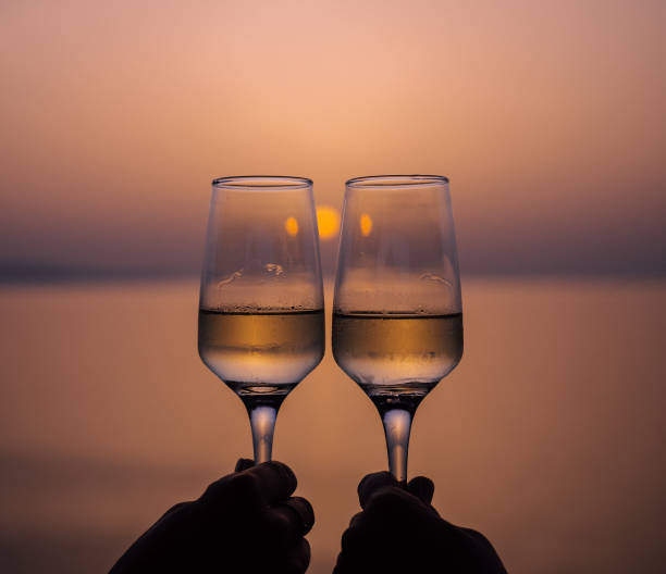 Close-up toasting with champagne at a beach stock photo