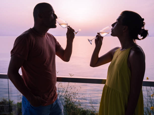 istock Romantic couple drinking champagne at a beach together 1465866658