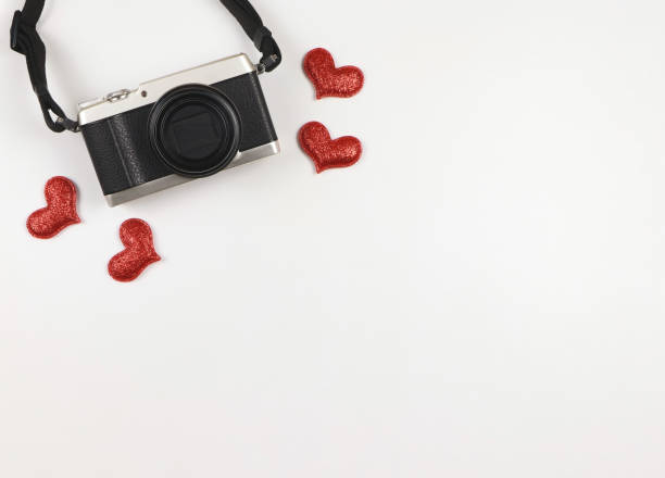 istock flat lay of digital camera with red glitter hearts on white background with copy space. 1465867939