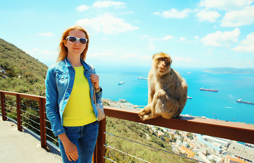 Woman tourist and macaque monkey. Gibraltar, United Kingdom