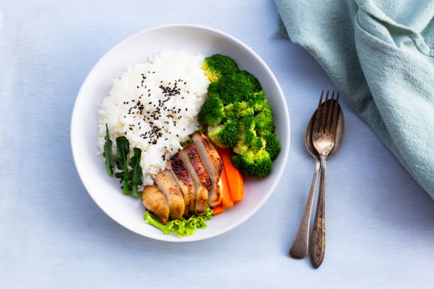 healthy food grilled chicken has rice broccoli carrot vegetables in plate on blue wood table. - teriyaki broccoli carrot chicken imagens e fotografias de stock