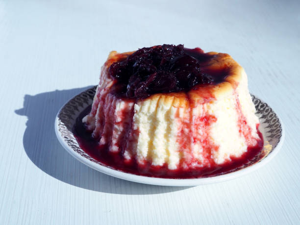 istock Cheesecake with cherry jam or sauce on a white plate. 1465882169