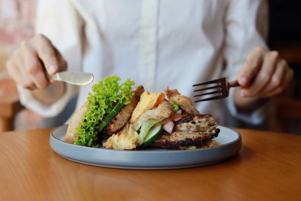 Cropped Image Of An Asian Woman Enjoying Breakfast, Toasted Bread With Grilled Chicken Meat, Front View Image.