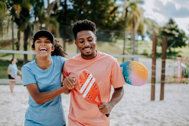 couple playing beach tennis - tennis couple women men imagens e fotografias de stock