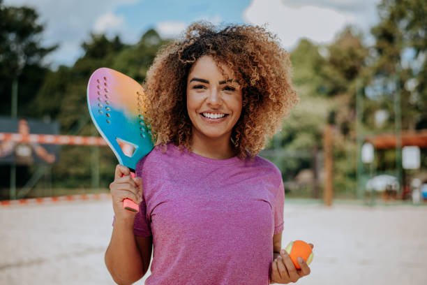 portrait d’une femme jouant au tennis de plage regardant la caméra - tennis women one person vitality photos et images de collection