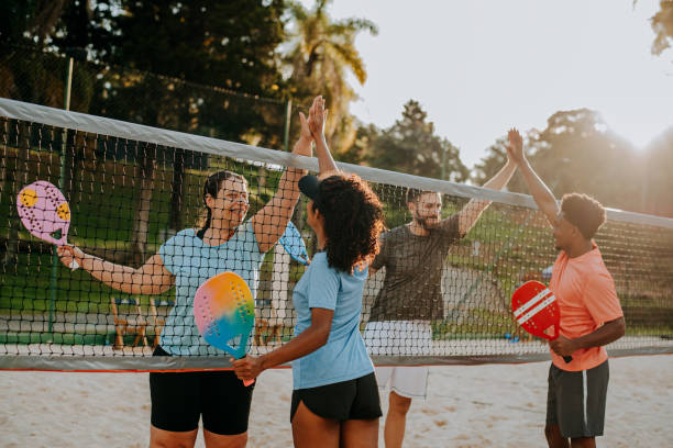 istock Group of friends playing beach tennis 1465896566