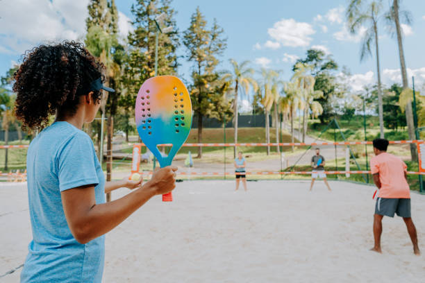 istock Group of friends playing beach tennis 1465897157