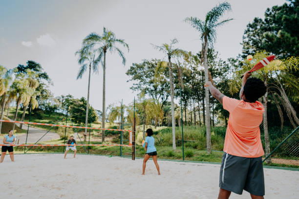 istock Group of friends playing beach tennis 1465897349