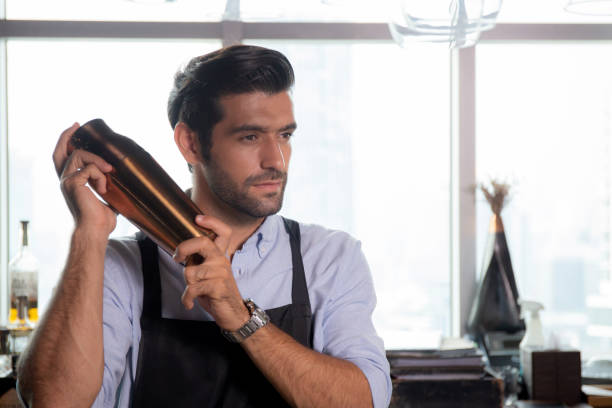 istock Young caucasian man is bartender holding and shaker for mixing beverage preparation serving with professional at counter, portrait handsome male, barman standing with confident at restaurant. 1465900329