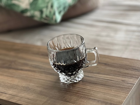 Glass cup of coffee in a wooden background