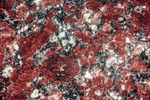 Nature granite texture background. Red granite tile texture close up. Polished decorative stone for photo design. Macro red grey granite decorative tile background may be used as a design pattern.