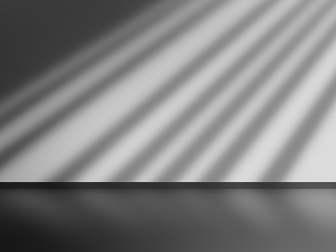 Light reflected on the wall and floor of an empty room. Black and white dark tones background.