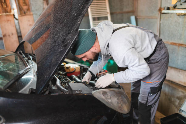 istock Young man working on his car in the garage at home 1465908445
