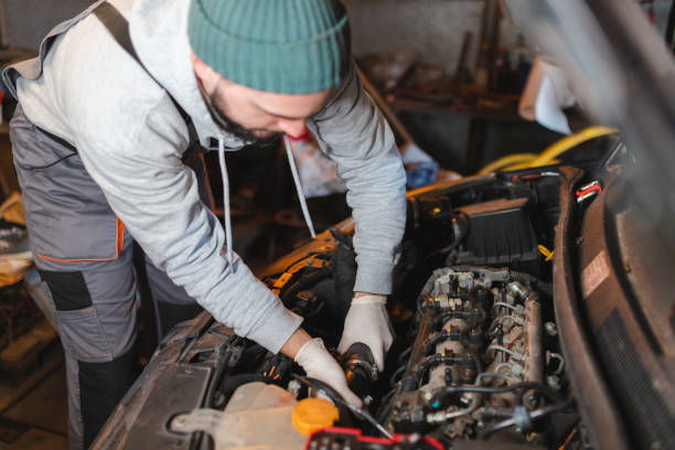 istock Young man wearing workwear working on a car in his garage 1465911064