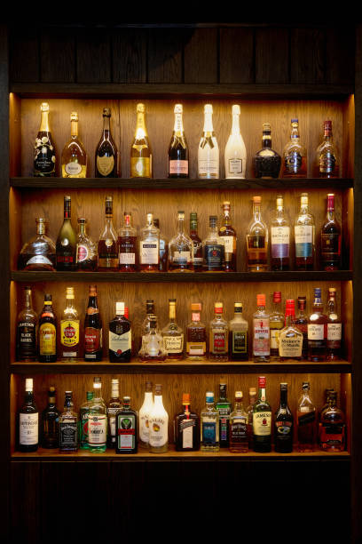 バーでアルコール入りのボトル。アルコール飲料のボトルが棚にあります。壁のバー。06.06.2021, ロシア ロストフ地方 - whisky alcohol bottle hard liquor ストックフォトと画像