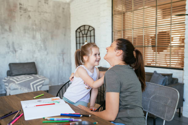 istock Mother and five year old daughter playing - drawing on paper and expressing creativity 1465915143