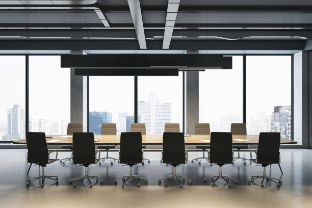 istock Front view on big light meeting table with rows of chairs around on concrete floor and great city view background from panoramic window in spacious minimalistic style office area. 3D rendering 1465918979