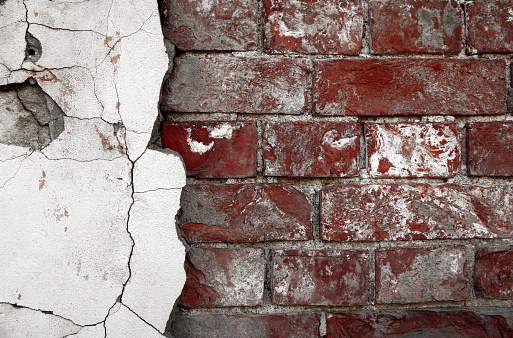 Old Red Brick Wall with plaster remnants, Brick wall background texture.