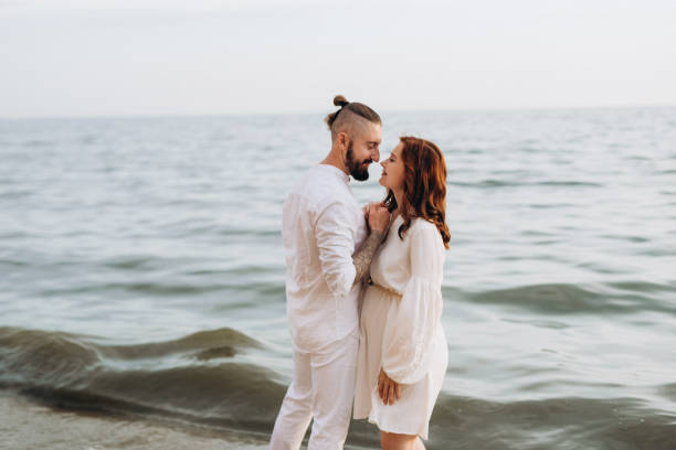 istock a guy with a girl in white clothes on the seashore 1465925056