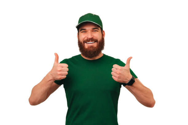 istock Handsome smiling delivery man wearing green uniform shows two thumbs up. 1465925521