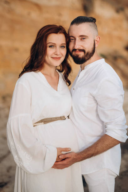 istock a guy with a girl in white clothes on the seashore 1465925741