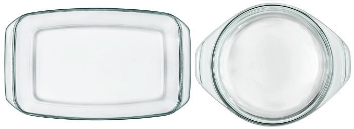 Studio shot of large oblong and round clear glass casserole baking pans, isolated on white background, high angle view.