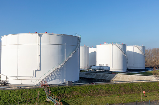 tank farm in Germany with white oil and petrol silos under blue sky