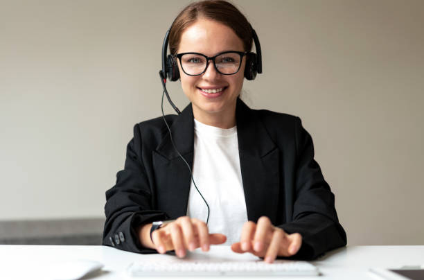 istock Representative customer service online center woman in headset smiling typing comments on keyboard while talking with customer online. 1465934513